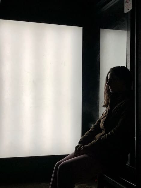 A movie critic sitting in a dark screening room, illuminated by the light of the screen, looking thoughtful and slightly skeptical.