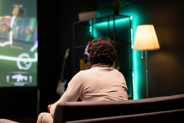 A person sitting in a dark movie theater, looking at a screen. The screen glows with different word snippets cut out from movie reviews, creating a collage-like impression of mixed opinions and anticipations.