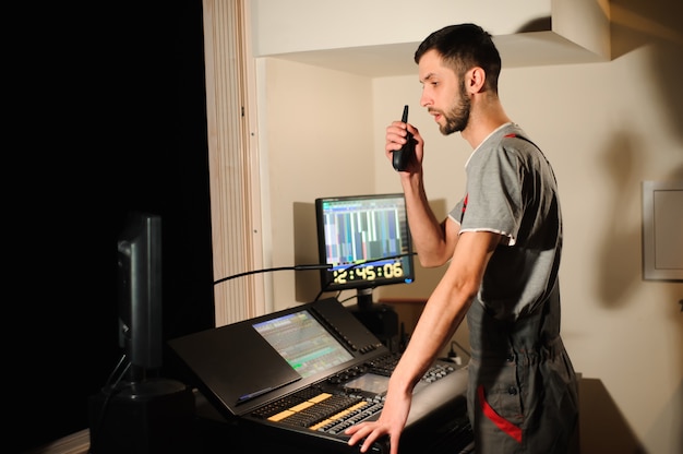 A sound engineer in a modern recording studio, working on audio mixing for a podcast, with advanced equipment and a visual representation of sound waves on a digital interface.