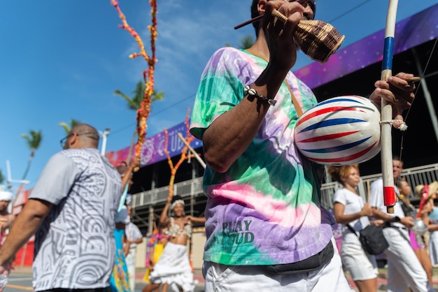 A vibrant photo of a street parade in Miami, celebrating Hispanic Heritage Month, featuring colorful floats, dancers in traditional costumes, and a large crowd enjoying the festivities.