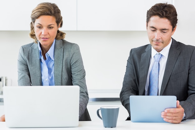 A close-up shot of SAG-AFTRA and AMPTP representatives at a negotiation table. Documents and laptops are spread across the table, with serious expressions on their faces, highlighting the intensity of the negotiations.
