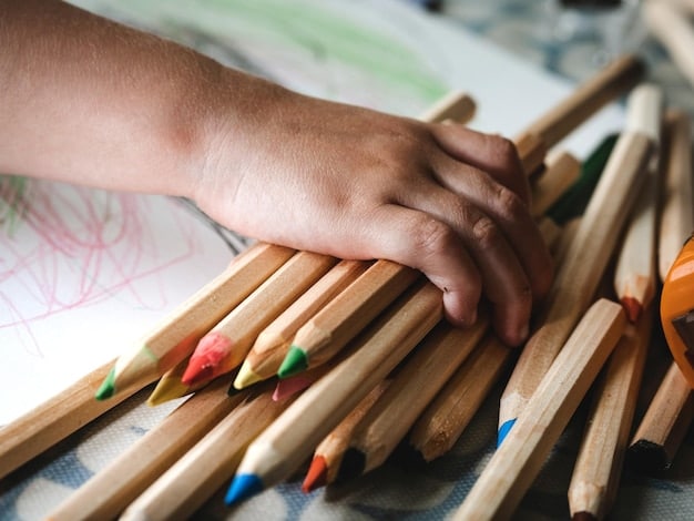 Close-up shot of the hands of middle school student carefully drawing in a sketchpad with colored pencils, surrounded by finished artwork displayed on the wall.