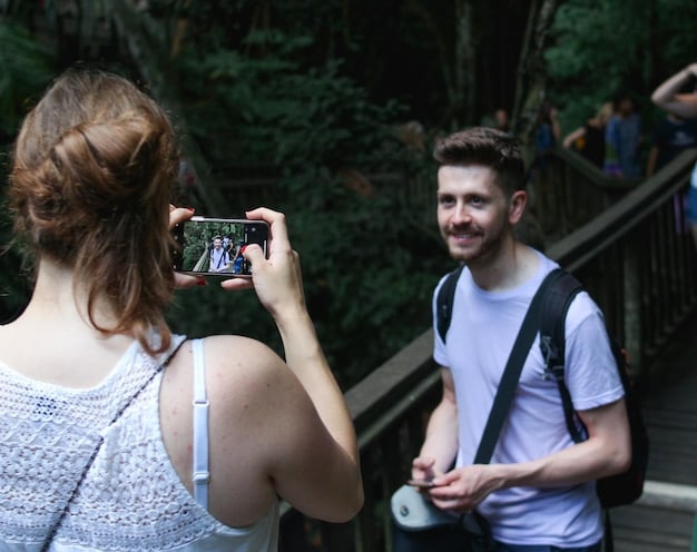 A group of tourists taking pictures in front of a recognizable filming location, such as a building or landscape. A tour guide is pointing out details about the location. The atmosphere is one of excitement and appreciation for the location's cinematic history.