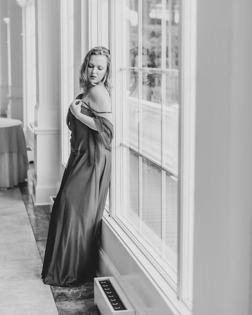 A black and white portrait of Audrey Hepburn in a classic Givenchy gown, exuding timeless elegance and sophistication, with a focus on the gown's clean lines and her graceful posture.